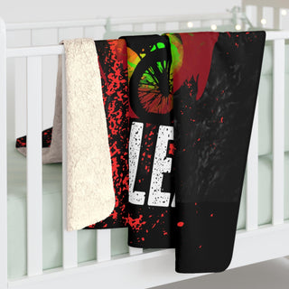 a white crib with a black and red blanket hanging from it's side