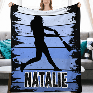 a woman holding up a blanket with a picture of a baseball player