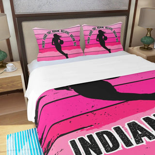 a bed with a pink and black bed spread