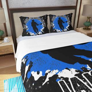 a bed with a blue and black comforter and two pillows