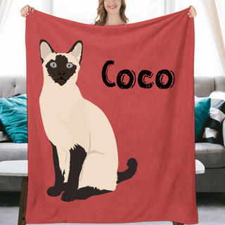 a woman holding a red blanket with a picture of a cat on it