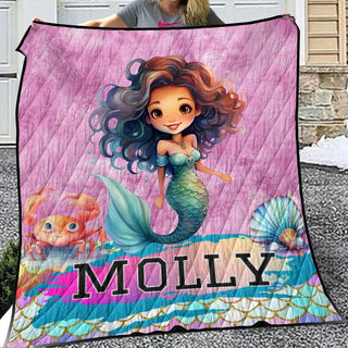 a girl holding a blanket with a picture of a mermaid on it