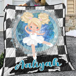 a girl holding a quilt with a picture of a ballerina on it