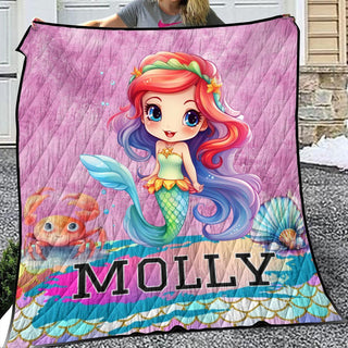 a woman holding a blanket with a picture of a mermaid on it