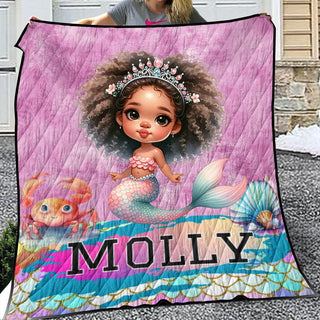 a woman holding a blanket with a picture of a mermaid on it