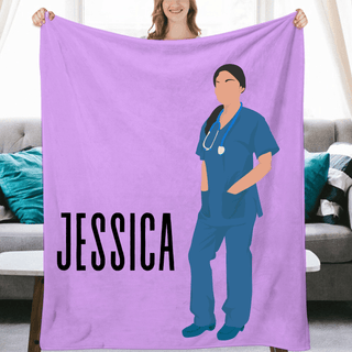 a woman holding up a purple blanket with a picture of a nurse on it