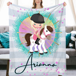 a girl holding a personalized blanket with a horse