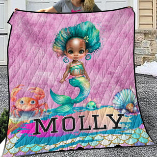 a woman holding a blanket with a picture of a mermaid on it