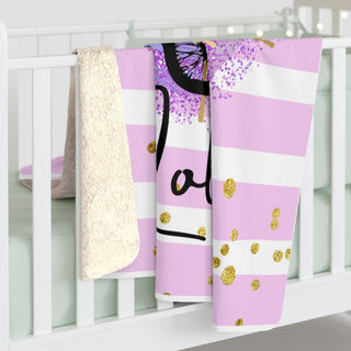 a pink and white crib with a butterfly blanket