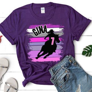 a purple t - shirt with a cowboy riding a horse